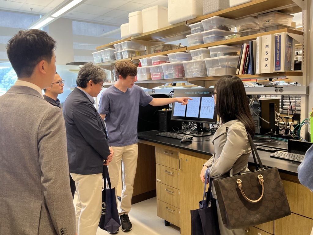 Touring of a lab with Hideo Takahashi (Vice Consul, Economic Affairs), [student 1], Consul General Seiichiro Takahashi, [student 2], Yurie Karikomi (Consulate, Researcher, Science and Technology).
